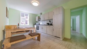 A modern kitchen with light wood cabinets, a built-in oven, and a window. - Apartment Schlossblick, Wernigerode (Wernigerode)