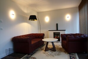 A living room with a sofa set, a small round table, a floor lamp, and a fireplace. - Chalet, Wendorf (Kuhlen-Wendorf)