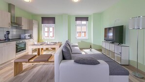 Een modern appartement met keuken, eethoek en woonkamer.