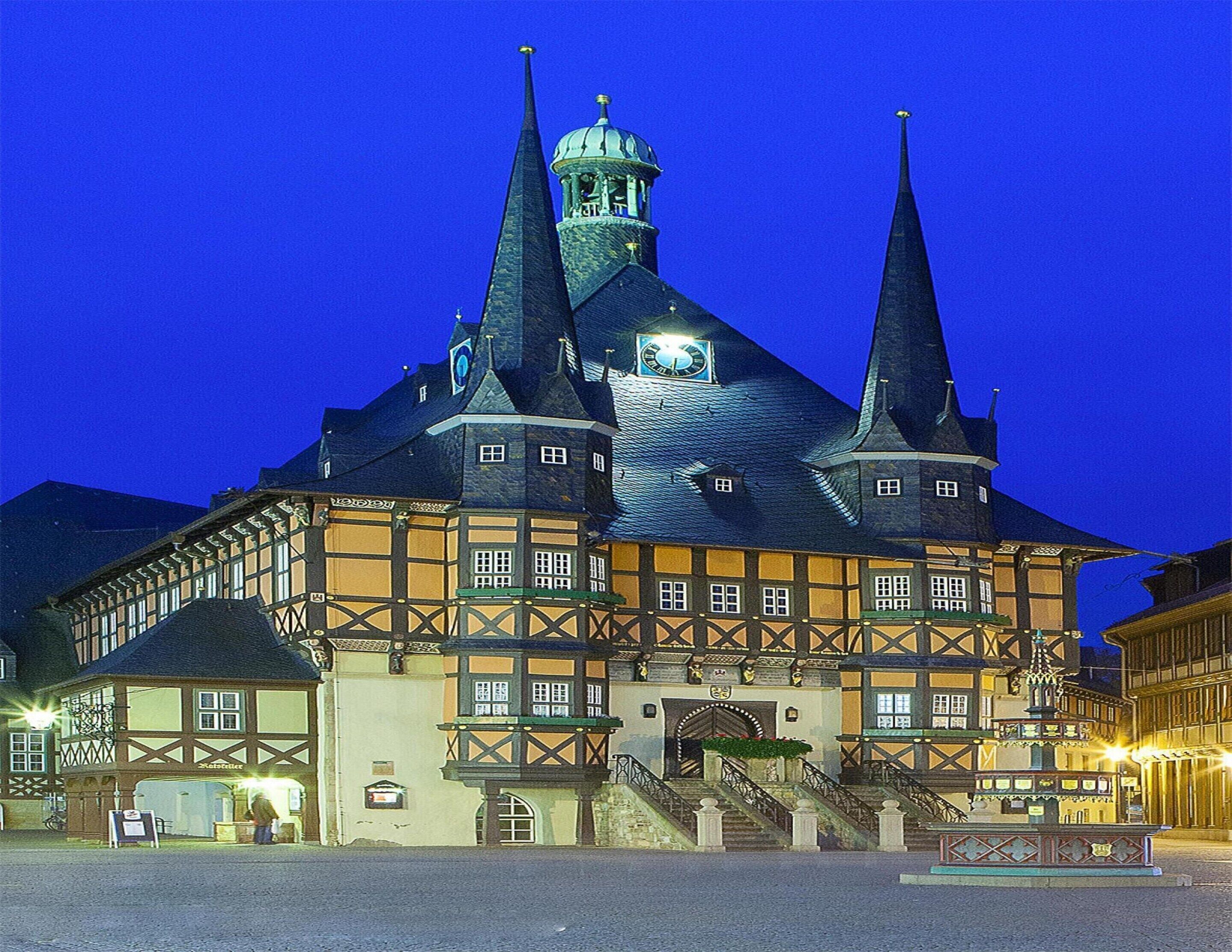 A historic building with multiple spires and a clock tower, featuring a traditional half-timbered facade.