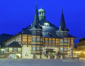 A historic building with multiple spires and a clock tower, featuring a traditional half-timbered facade. - Apartment Remise, Wernigerode (Wernigerode)