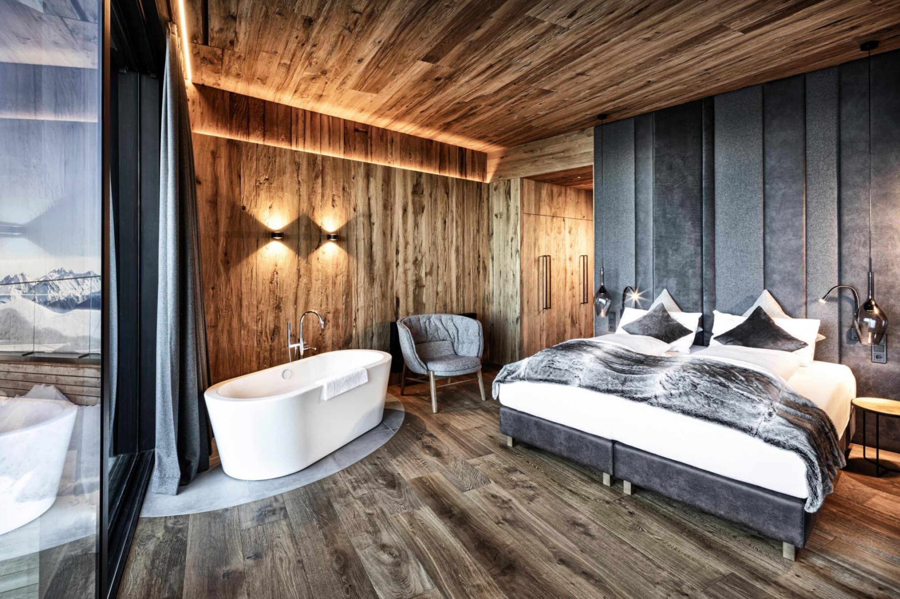 Une chambre moderne avec un grand lit, une baignoire et un fauteuil.