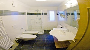 Un bagno con due lavandini, una doccia e un water.