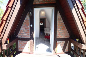 An attic room with a sloped roof, brick walls, and a wooden balcony. - Bungalow in Kolczewo With Parking Space (gmina Wolin)