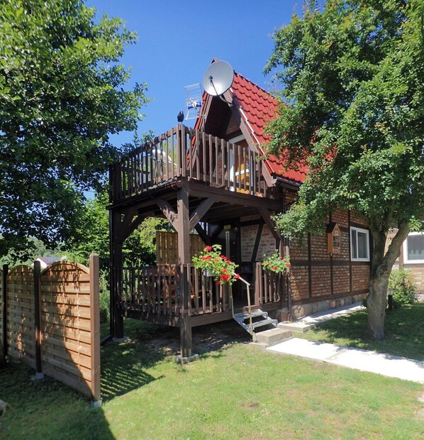 A wooden house with a red roof, a balcony, and a satellite dish. - Bungalow in Kolczewo With Parking Space (gmina Wolin)