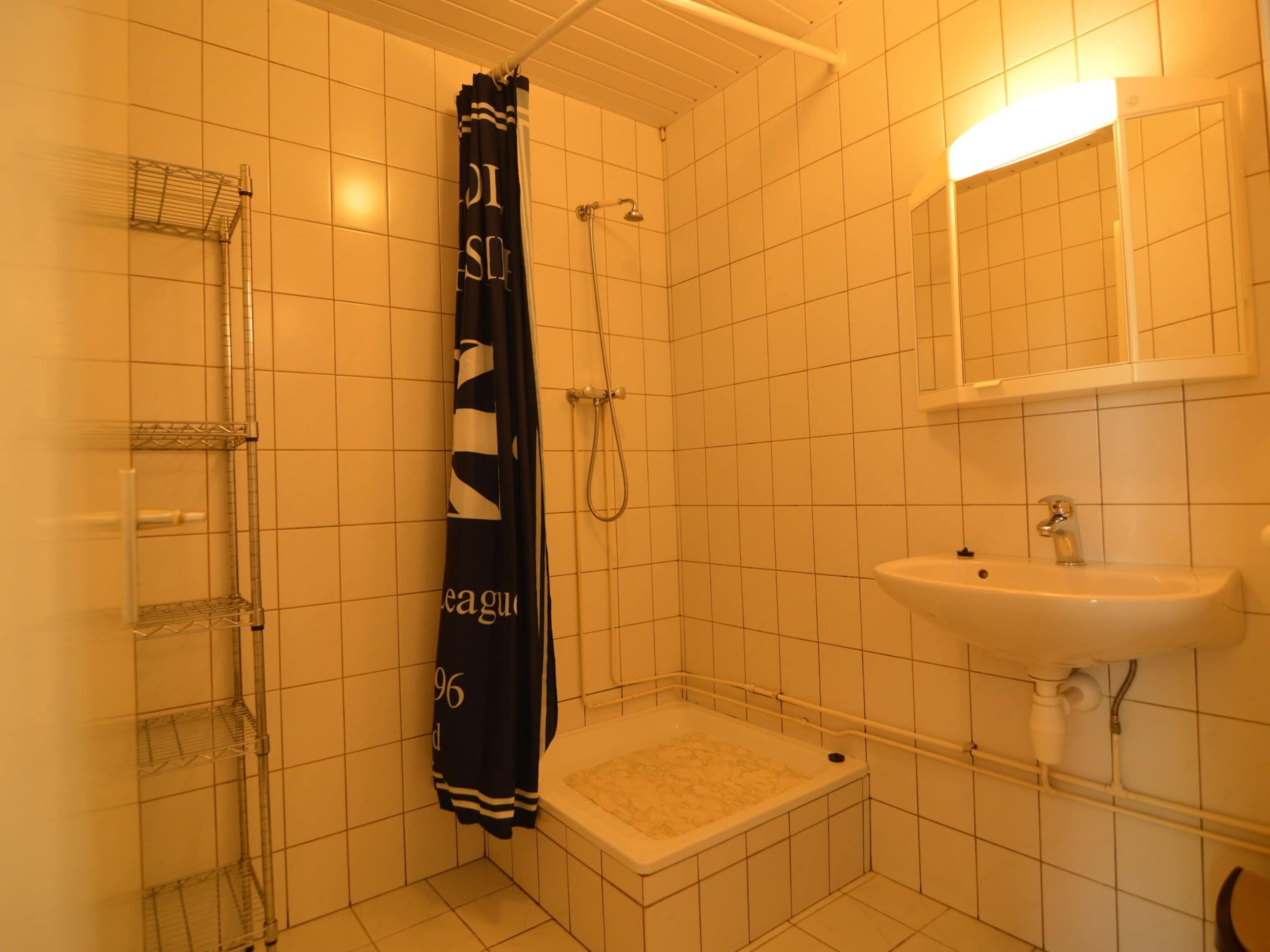 Un bagno con doccia, vasca e lavandino.