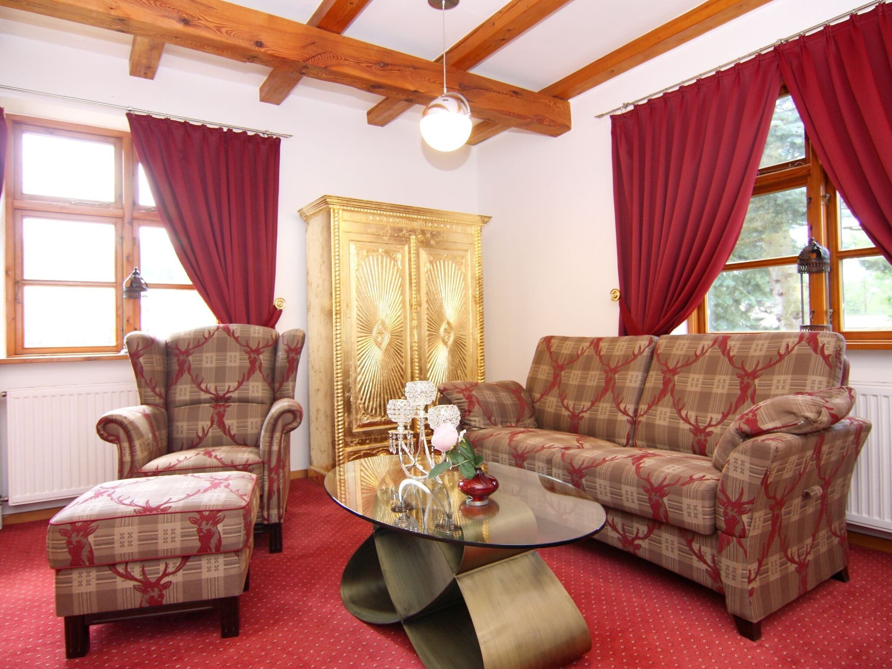 A cozy living room with a sofa, armchair, and a glass coffee table.
