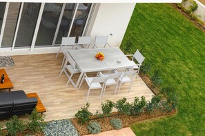 An outdoor patio with a table and chairs, a sofa, and a small garden area with plants and a gravel path. - Villas Acrotel Porto Brava, Ormos Panagias (Sithonia)