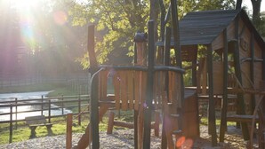 A playground with a climbing structure and a wooden playhouse. - Chalet, Wendorf (Kuhlen-Wendorf)