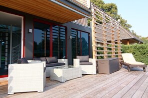 An outdoor deck with wicker furniture, including sofas and a lounge chair, and a glass-top coffee table. - Chalet, Wendorf (Kuhlen-Wendorf)
