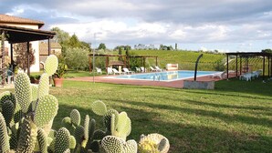 A pool area with lounge chairs and a cactus garden. - Agriturismo Poggio al Sole, Vinci (Vinci)