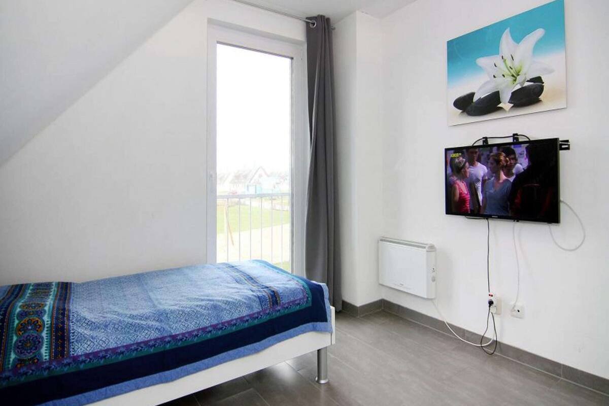 Una camera da letto con un letto, una TV e una finestra vista all'esterno.