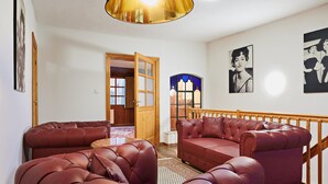 A living room with a red leather sofa set, a wooden staircase, and a stained glass window. - Holiday Home Oliver, Wendorf (Kuhlen-Wendorf)