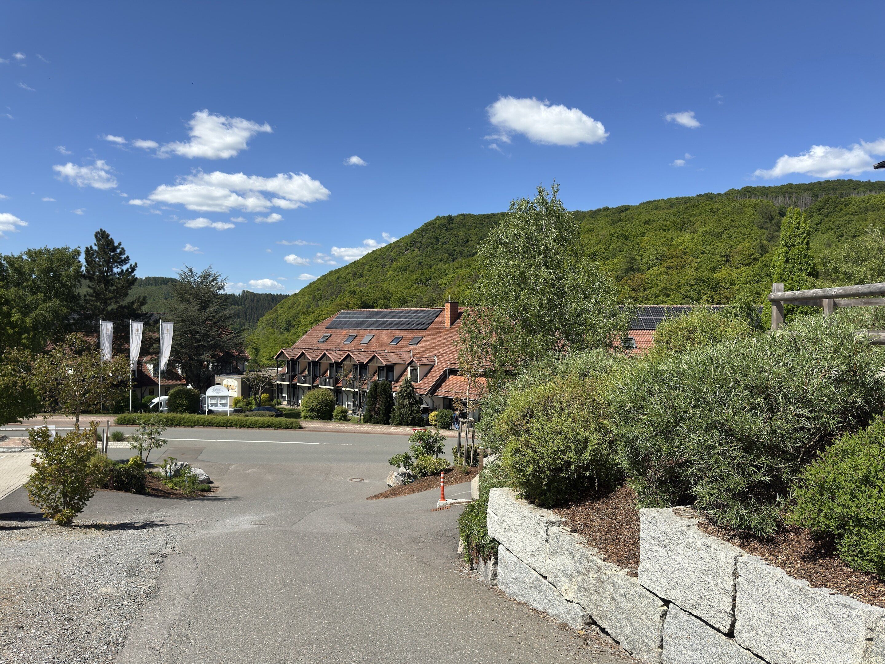 A building with a sloped roof, solar panels, and a stone wall.