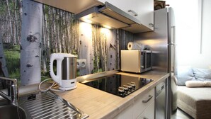 Une cuisine moderne équipée d’une cuisinière intégrée, d’une bouilloire, d’un grille-pain et d’un réfrigérateur.