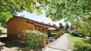 Un edificio con un vialetto in pietra che vi conduce, circondato da vegetazione e alberi.