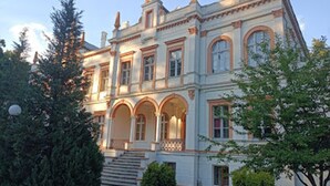 Un grand bâtiment historique doté de nombreuses arcades et d’une façade symétrique.