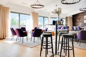 A modern dining area with high ceilings, large windows, and a view of the outdoors. - Apartment in Matrei in Osttirol With a Washing Machine (Matrei in Osttirol)