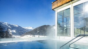 A modern building with large windows overlooking a clear blue sky and a snowy mountain landscape. - Apartment in Matrei in Osttirol With a Washing Machine (Matrei in Osttirol)
