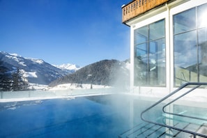 A modern building with large windows overlooking a clear blue sky and a snowy mountain landscape. - Apartment in Matrei in Osttirol With a Washing Machine (Matrei in Osttirol)
