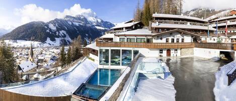Ein Hotel mit Pool, Skipisten und Bergblick.