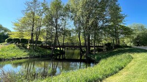 A serene park with a pond, trees, and a bridge. - Bungalow in Lubben With a Terrace (Lübben (Spreewald))