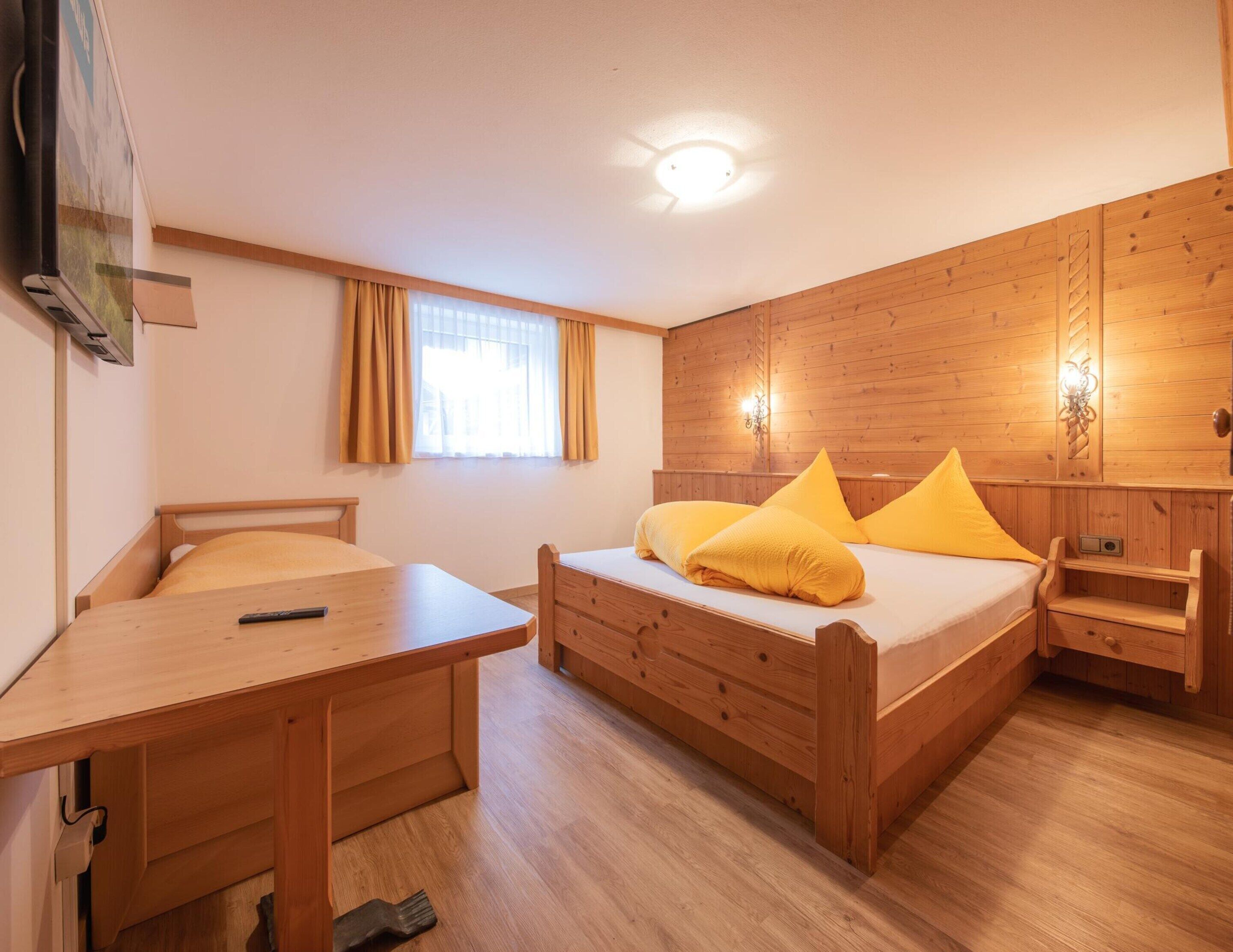 A room with a bed, a desk, and a window.