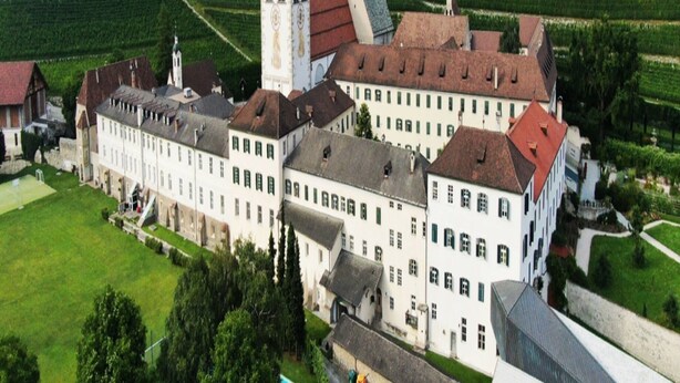 A large, historic building with multiple wings and a prominent tower, surrounded by lush green fields. - Apartment in Neustift With a ski Storage (Neustift Im Stubaital)