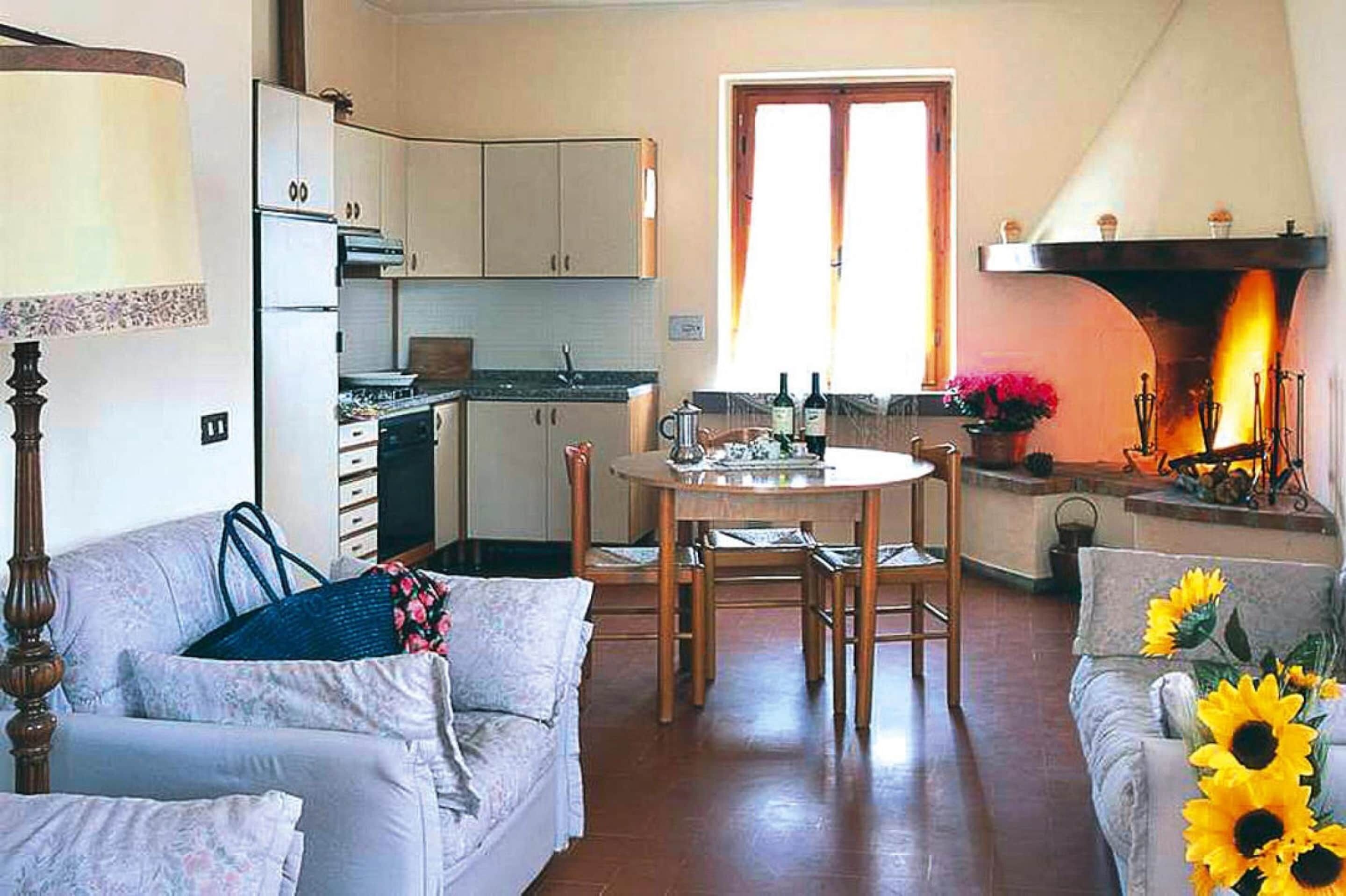 Una sala de estar acogedora con un sofá, una mesa de comedor y una chimenea.