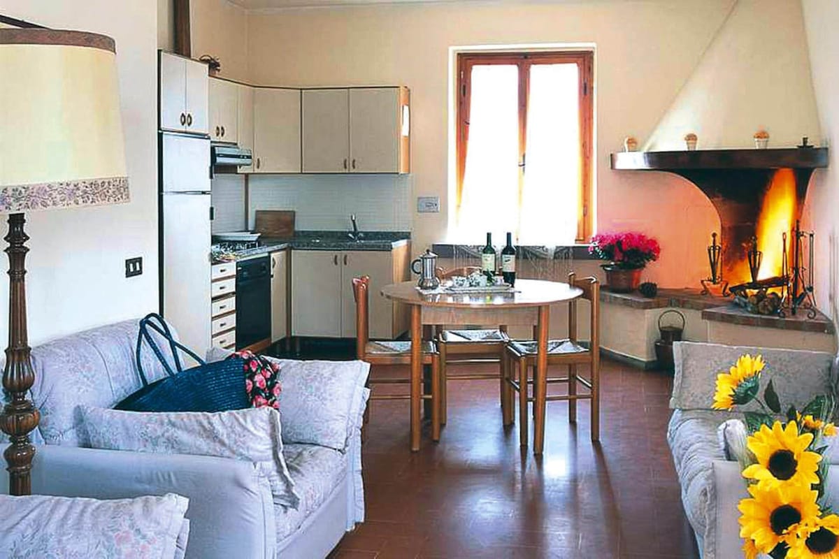 Un salon chaleureux avec un canapé, une table à manger et une cheminée.