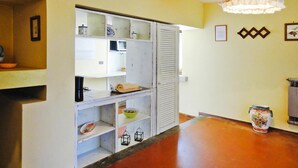 A kitchen with white cabinets, a microwave, and a sink. There is a decorative vase on the counter. - Agriturismo La Scopa, Montaione (Montaione)