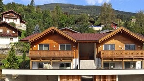 Un chalet en bois doté d’un balcon, situé dans un cadre montagneux.