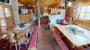 Ein gemütliches Blockhaus-Interieur mit Holzbalken, einer Bar und einem Essbereich mit Bänken.