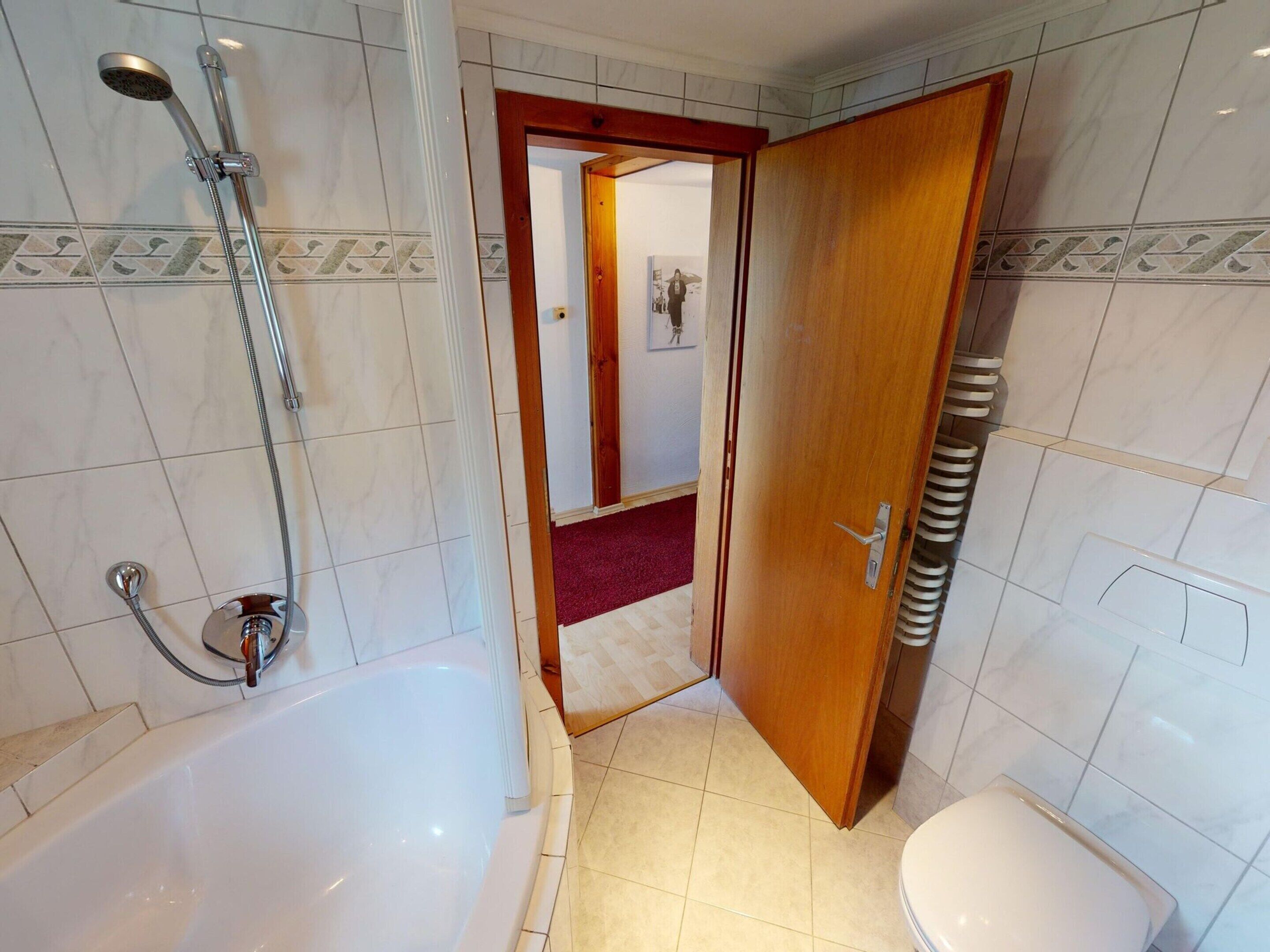 Ein Badezimmer mit Badewanne, Dusche und Toilette.