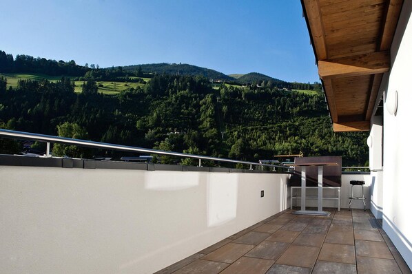A balcony with a view of a green valley and hills.