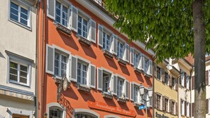 A row of traditional European buildings with uniform facades, featuring multiple windows with shutters and balconies. - Apartments Haus Burgund, Meersburg (Meersburg)