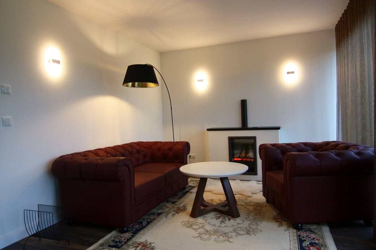 A living room with a sofa set, a small round table, and a floor lamp.