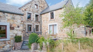 A stone building with a staircase leading to a door, surrounded by greenery and a fence. - Beautiful Gite in Jalhay 5 Minutes From the Hautes Fagnes (Jalhay)