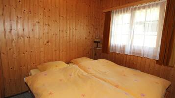 A room with wooden walls and a large bed with floral bedding.