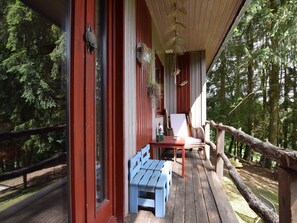 A wooden deck with a blue bench and a white chair, surrounded by trees. - Lively Holiday Home With Garden, Barbecue, Garden Furniture (Houffalize)