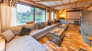 Ein modernes Wohnzimmer mit einer großen Eckcouch, zwei Couchtischen und einem Kamin.