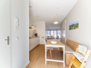 Ett modernt kök med matplats, en bänk och utsikt över vardagsrummet.