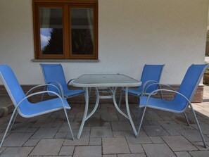 A patio with a table and four blue chairs. - Holiday Home not far From the Small Town of Durbuy (Durbuy)