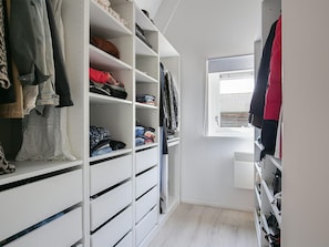A walk-in closet with multiple shelves and drawers for storage, a window with blinds, and a wooden floor. - Restful Holiday Home in Grou With Terrace and Garden (Grou)