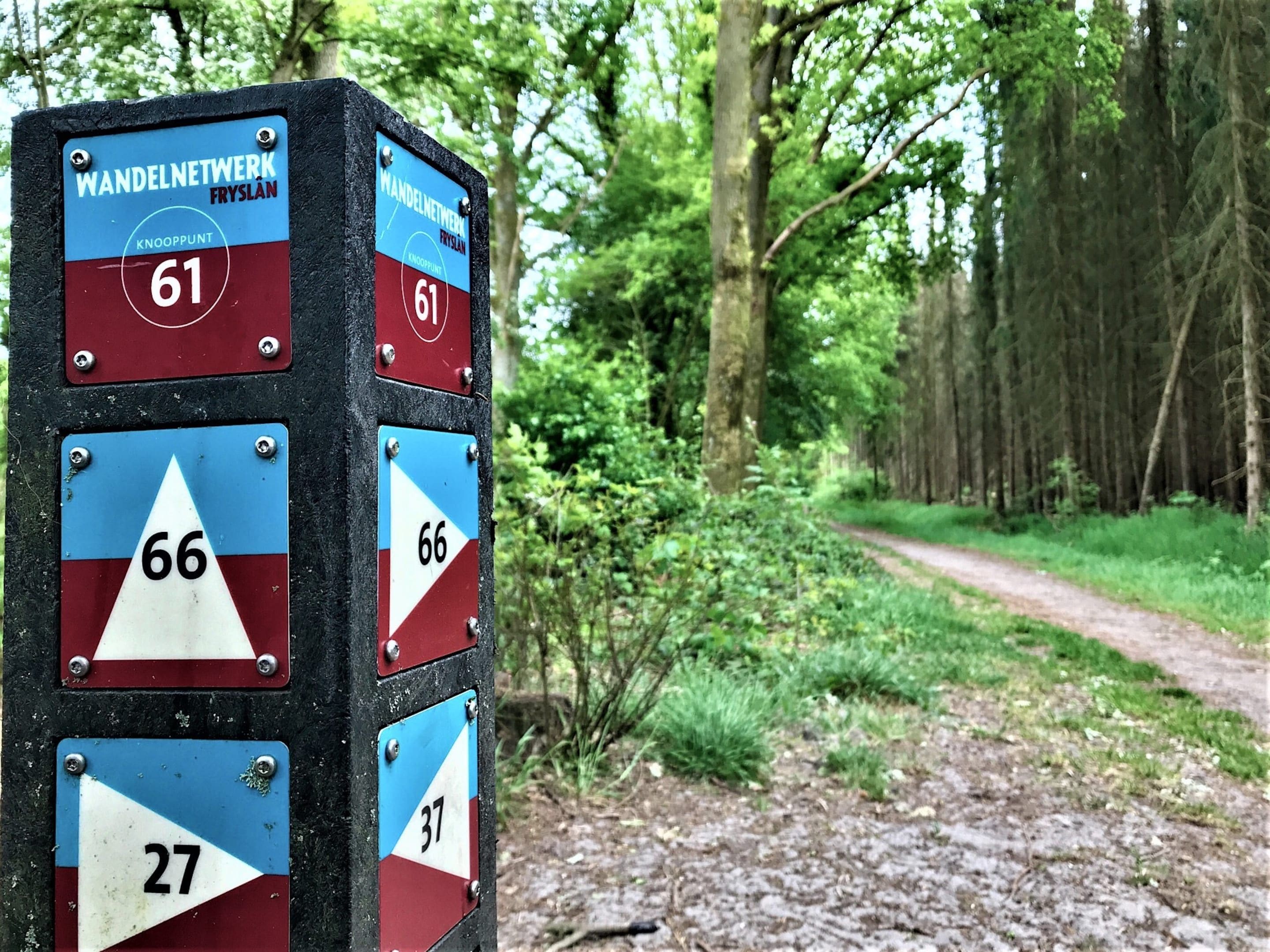 A trail sign with directional markers and numbers indicating distances in kilometers.