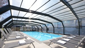 A covered swimming pool with lounge chairs and a glass ceiling. - Fancy Holiday Home in Sainte-cecile With Pool House & Indoor Pool (Florenville)