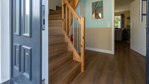A staircase with wooden railings leading to a room with a view.
