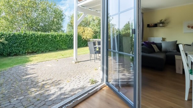 A modern living room with a large sliding glass door leading to a patio area.