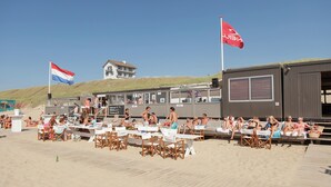 En restaurang vid stranden med uteservering och utsikt över havet.