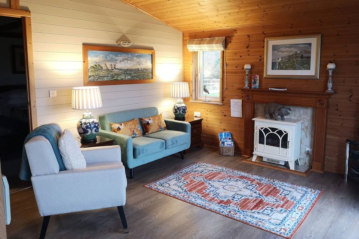 Un salón acogedor con sofá, sillón y chimenea.